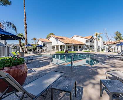 a pool with tables and chairs around it at the resort