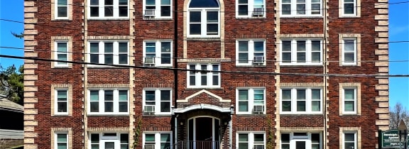 a red brick building with stairs in front of a street
