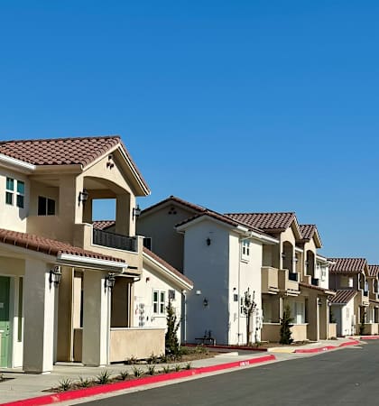 A row of houses with a red curb in front.