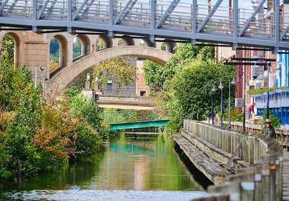 A bridge over a river with a greenish hue.