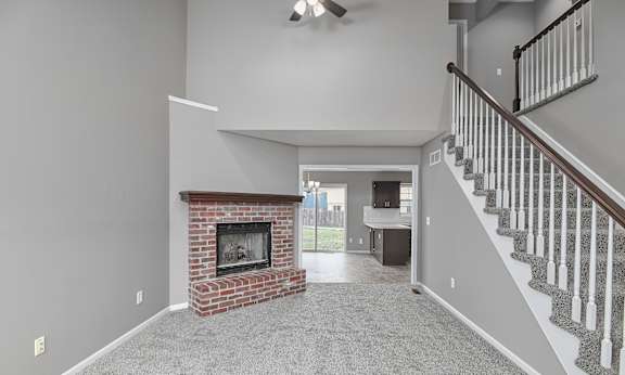 A living room with a fireplace and a staircase.