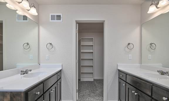 A bathroom with two sinks and a large mirror.