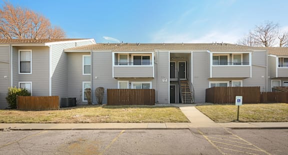 Apartment building with a brown fence in front.