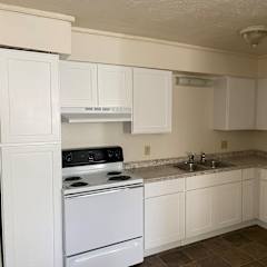 a kitchen with white cabinets and white appliances