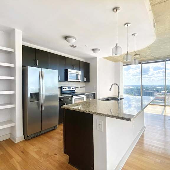 a kitchen with a large island and stainless steel appliances