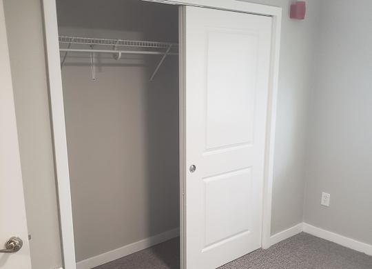 A white cabinet with a mirror above it.