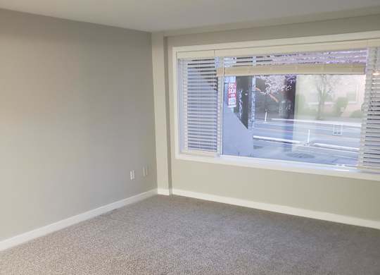 A room with a window and a wallpapered wall.