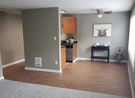 A small kitchenette with a microwave, oven, and a fan.