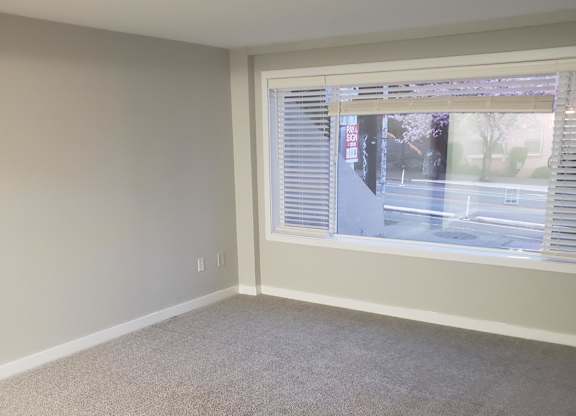 A room with a window and a wallpapered wall.