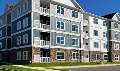 an apartment building on a street corner with a blue sky
