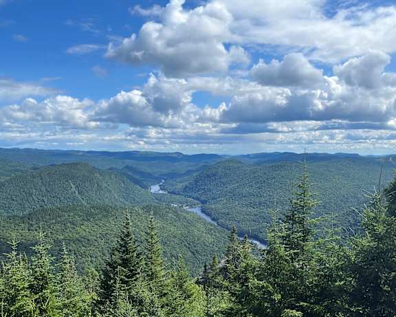 a view of the mountains and a river in the valley