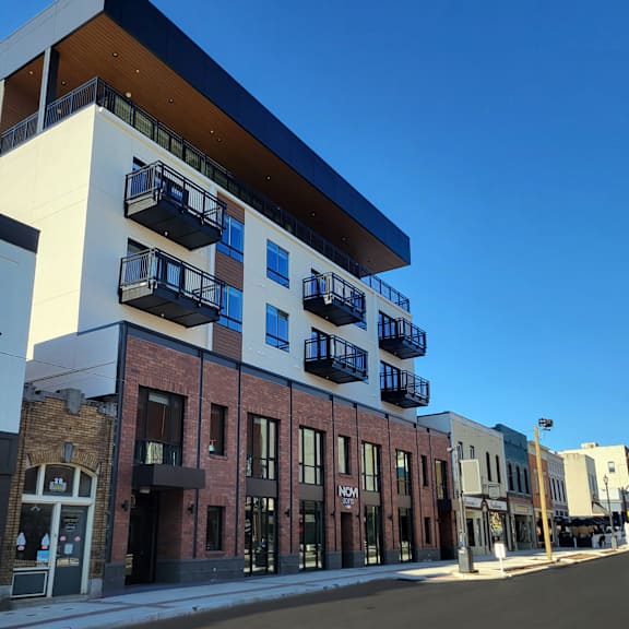The Novi building is a modern structure with a glass facade and a mix of white and dark-colored windows.