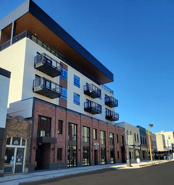 A street view of a multi-story building with balconies.