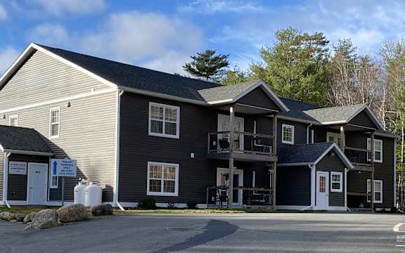 A large building with a parking lot in front.