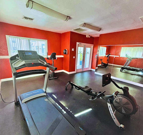 a workout room with red walls and exercise equipment