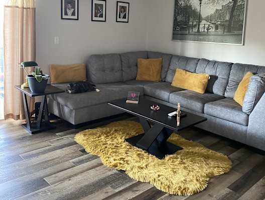 a living room with a gray couch and a ceiling fan