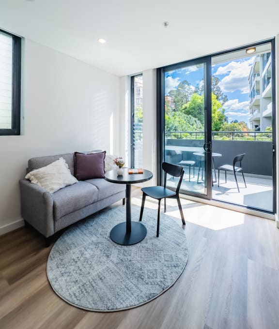 a living room with a couch and a table in front of a sliding glass door