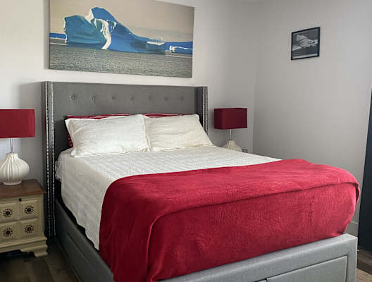 a bedroom with a bed and a painting of icebergs on the wall