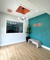 A room with a wooden floor and a wall with the word "CARISMA" on it.