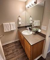 A bathroom with a sink, mirror, and towel rack.