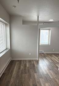 A room with wooden flooring and a window.