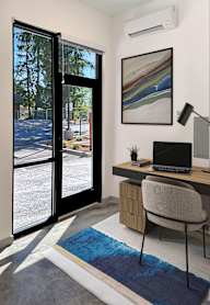 A room with a desk and chair with a laptop on it.