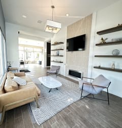 a living room with a table and chairs and a television at The Bryant Apartments at Yorba Linda, California