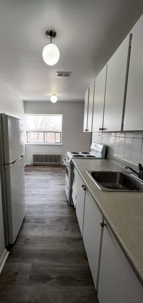 a small kitchen with a sink and a refrigerator