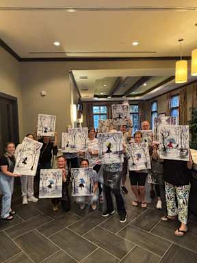 A group of people holding paintings of trees.