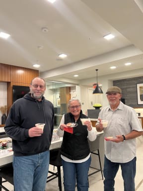 three people holding cupcakes in a kitchen
