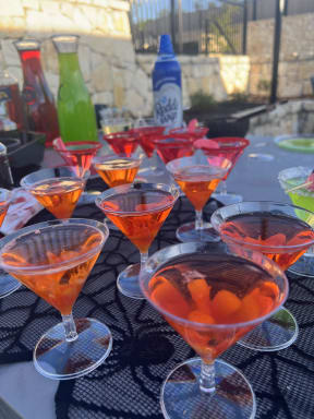 a row of orange drinks in martinis glasses on a table