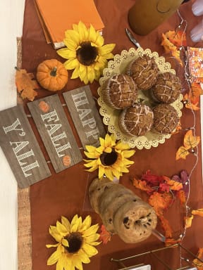 a tray of cookies on a table with sunflowers and pumpkins