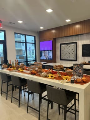 a buffet table with food on it in a room with chairs