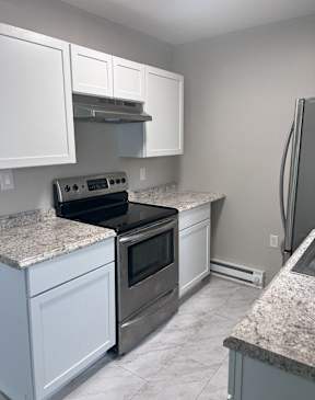 A kitchen with white cabinets and granite countertops.