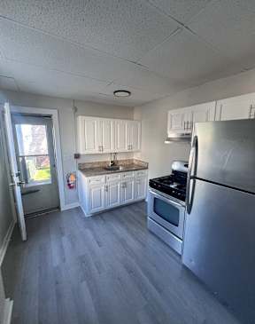 A kitchen with a stainless steel refrigerator, oven, and microwave.