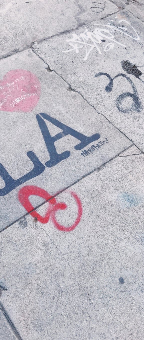 a piece of graffiti on the sidewalk on a sidewalk
