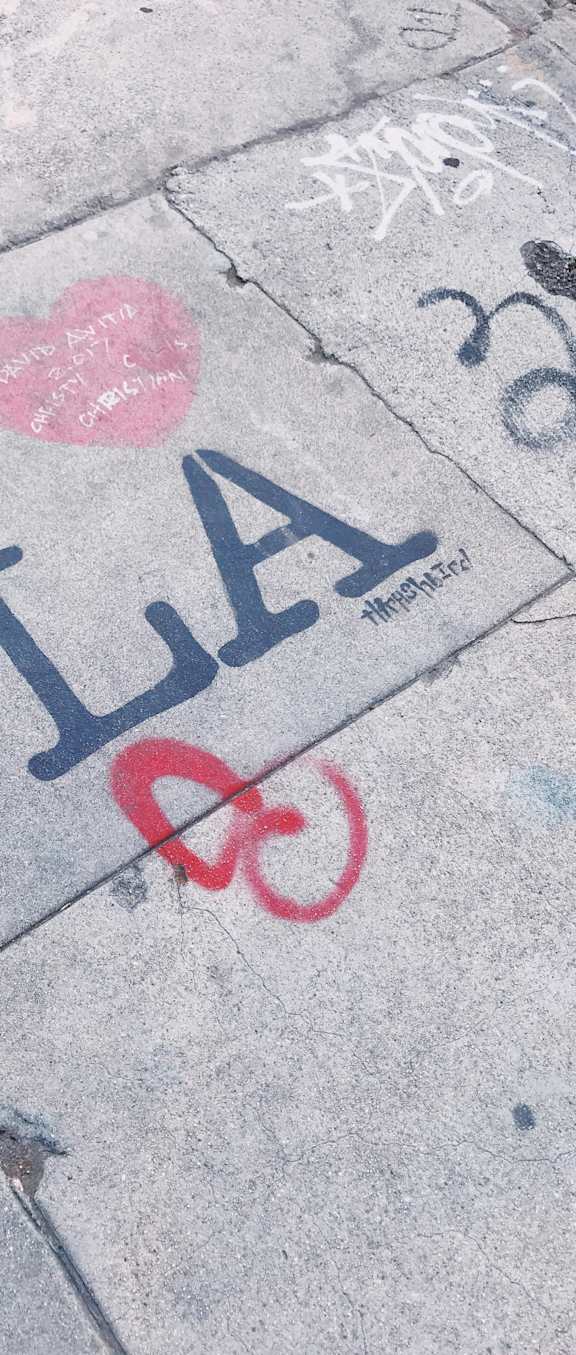 Graffiti on the ground with a heart and a bike.