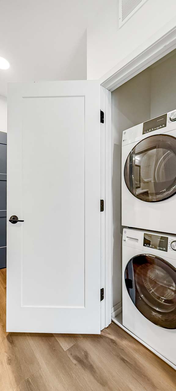 A white cabinet with two washing machines stacked on top of each other.