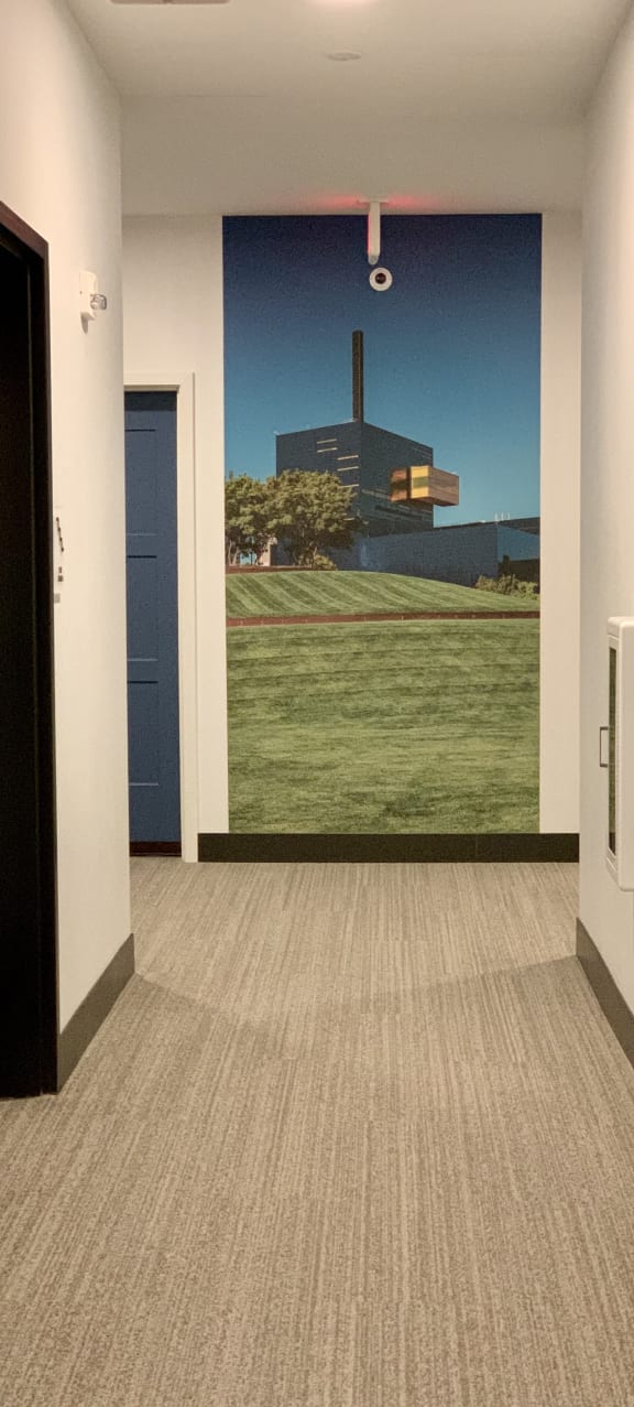 a hallway with a mural on the wall and a carpeted floor