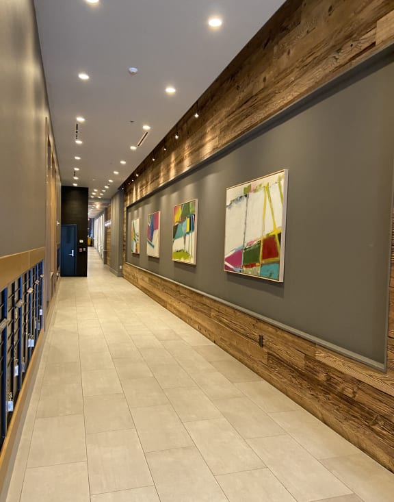 a long hallway with paintings on the wall and a tile floor at Tribeca NOMA apartments