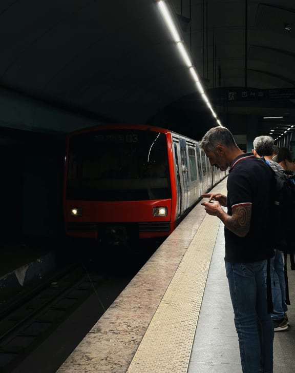 a man standing at a train station looking at his cell phone  at Sanger Place, Lorton, 22079