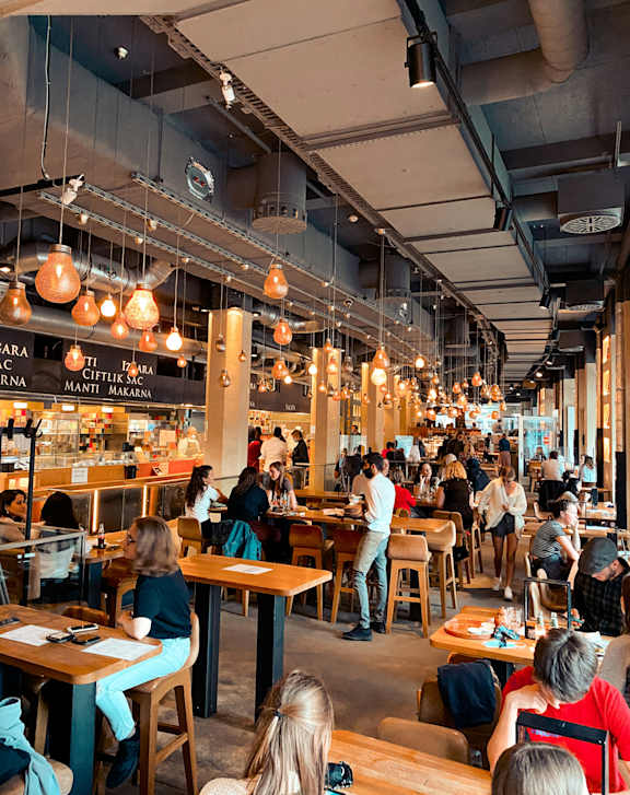A busy restaurant with people sitting at tables and eating.