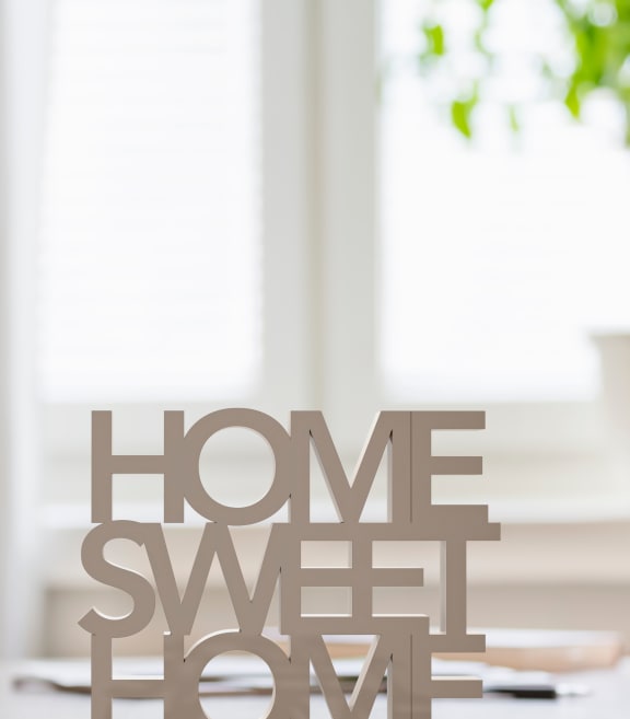 a home sweet home wood sign on a table