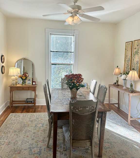 a dining room with a table and chairs and a ceiling fan