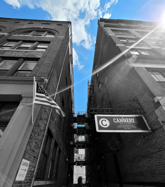 a flag flying between two buildings on a street
