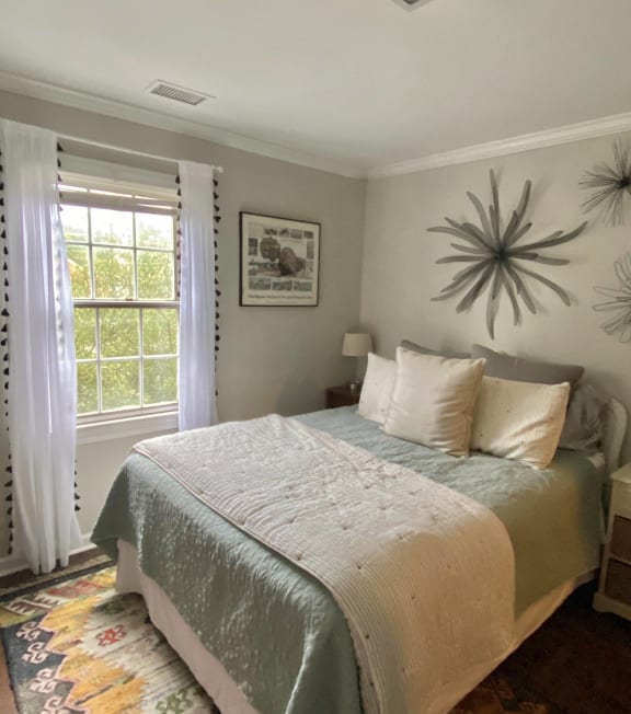 the master bedroom has a large bed and a large window