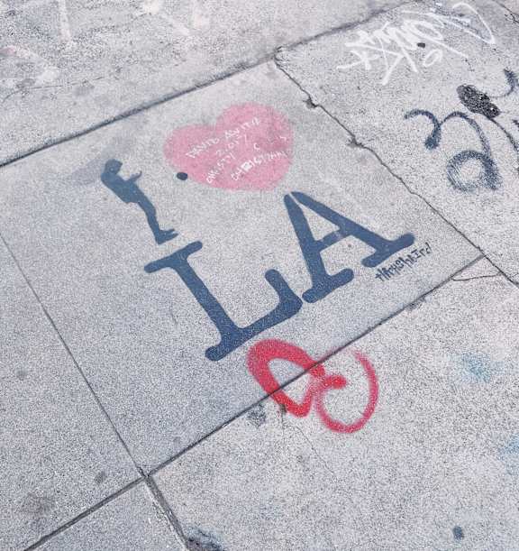 Graffiti on the ground with a heart and a bike.