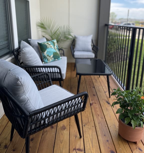 a patio with wicker furniture and a potted plant