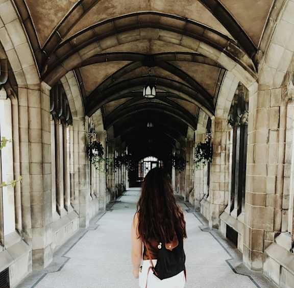 a woman walking through a tunnel in a building