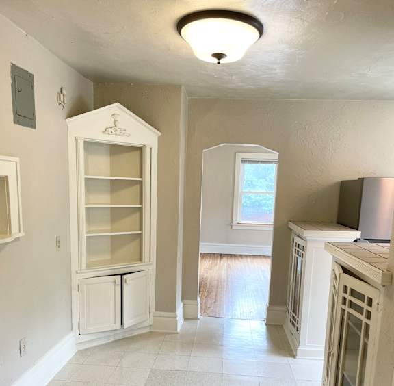 A kitchen with white cabinets and a black countertop.